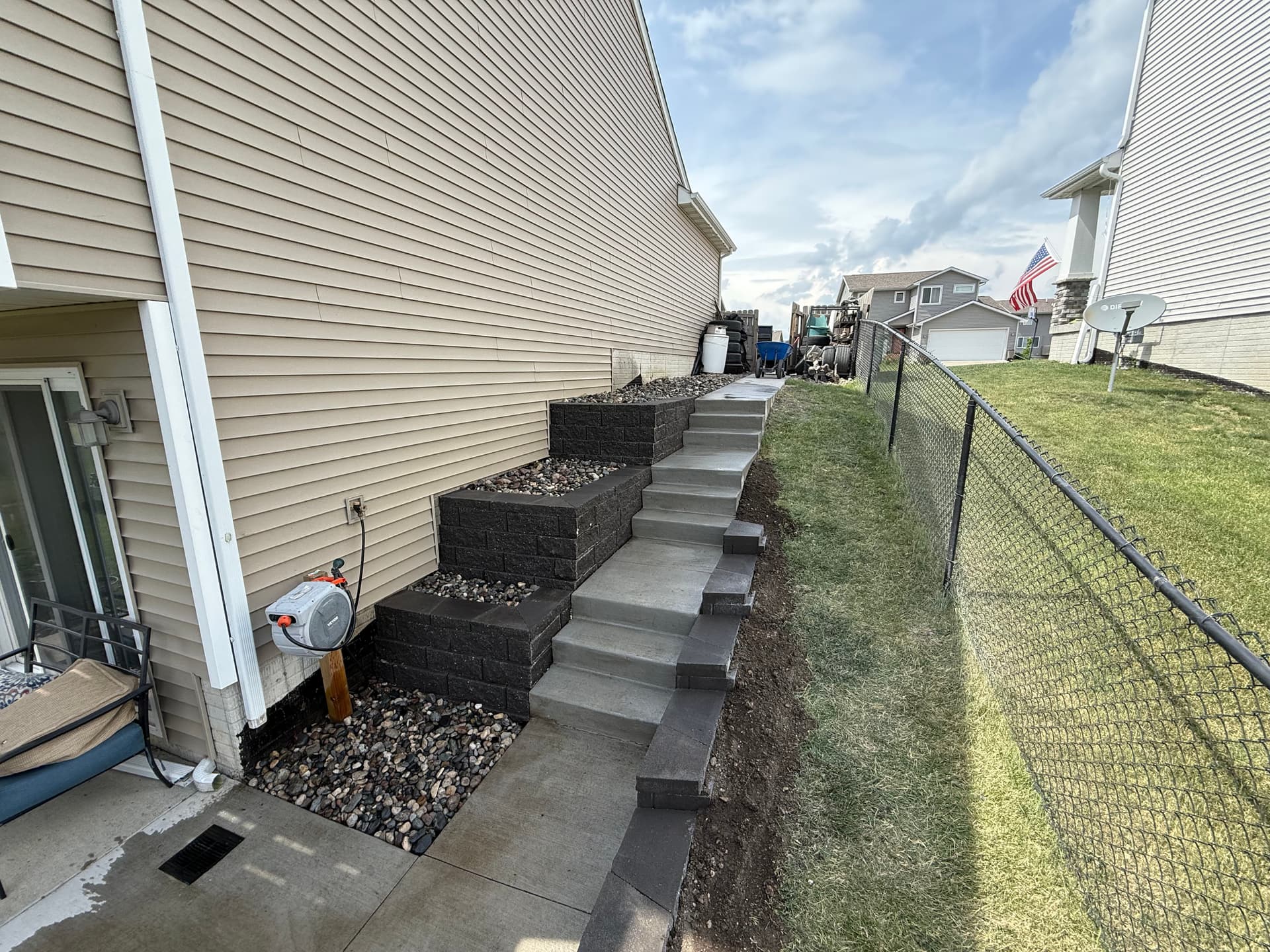 Three Retaining Walls and Concrete Steps Fix a Tough Side Yard Slope image