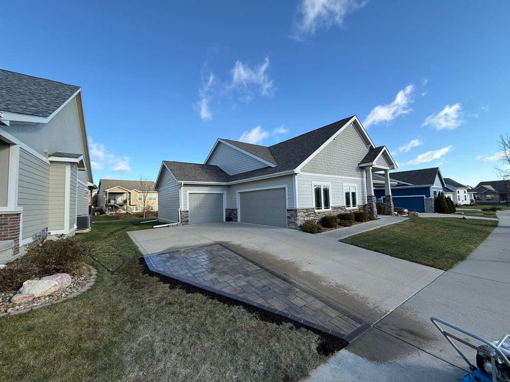 Modern suburban home with grey siding, two-car garage, and well-maintained landscaping.